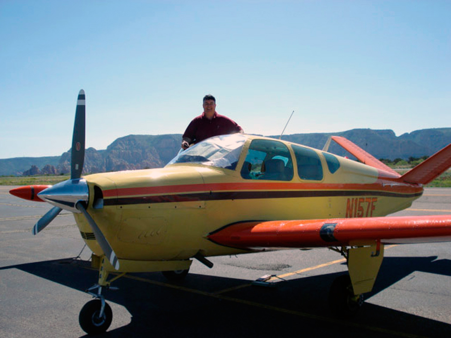 Man stands on the wing of a Beechcraft Bonanza